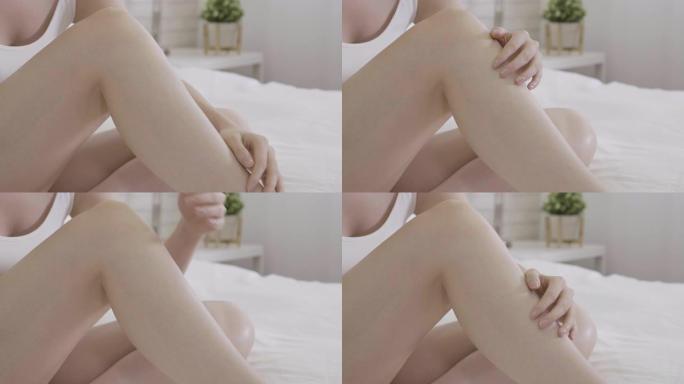 女人的手在床上抚摸性感的长腿