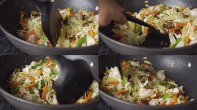 女士在平底锅上煎蔬菜。中国菜。素食节。