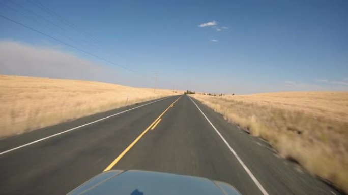 汽车视点驾驶农村，道路两侧有干草田