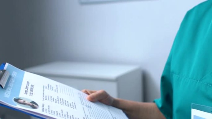 成熟的护士在笔记本电脑上工作，在患者在线医疗表格中填写数据