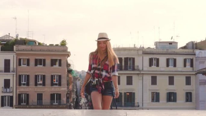 年轻的金发女子带着老式相机在罗马走上西班牙台阶，拍照，意大利。