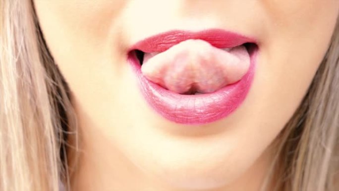 女人的舌头诱人地舔嘴唇。