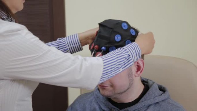 医生给一个人戴上耳机，用于研究人脑