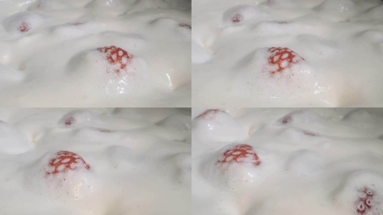 旋转成熟的草莓，上面覆盖着厚厚的奶油。相机旋转360度，特写。