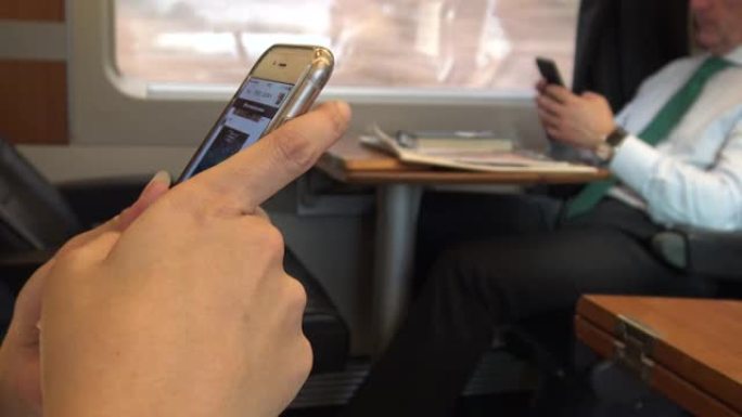 4k亚洲女性在火车上使用移动触摸屏智能手机做工作