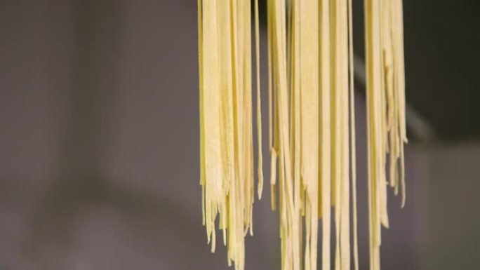 向上倾斜，将新鲜的意大利面条挂在黄色的绳子上。自制意大利面。