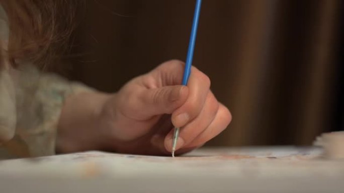 女孩用细蓝色流苏在画布上划水