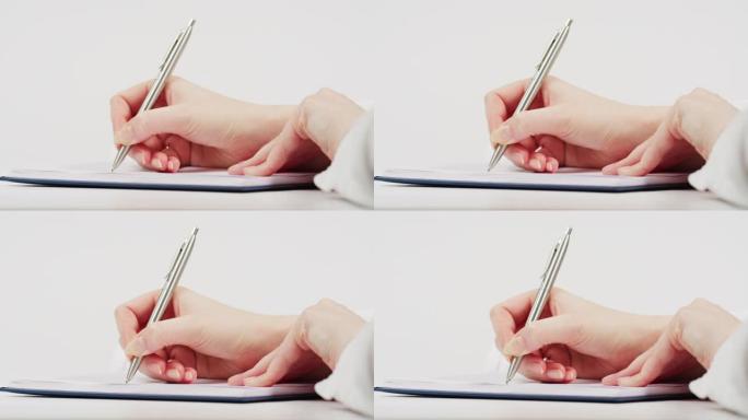 一个女人在纸上写字的手