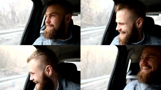 一位大笑的大胡子时髦男性的特写肖像坐在后座的汽车里，一边环顾四周一边冥想