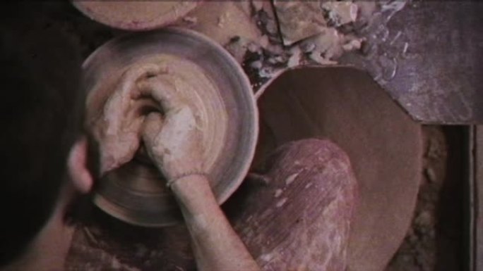 陶工用一壶粘土制成。复古效果。一个人在陶工的轮子上做花瓶