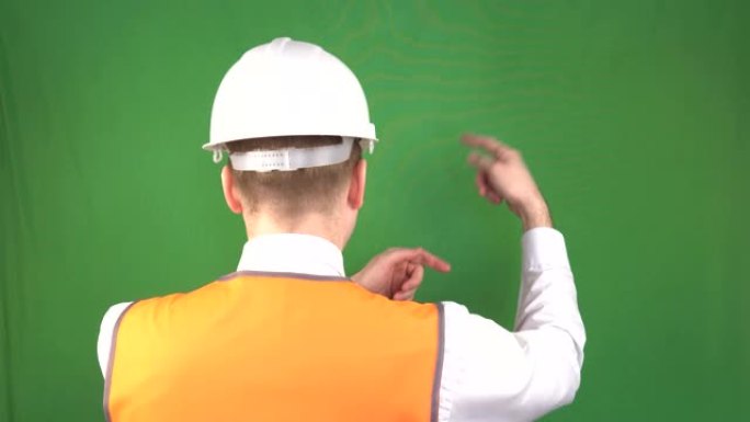 戴着防护头盔和信号背心的男性建筑商在建筑工地，安全工程，工业，hromakey展示手势命令