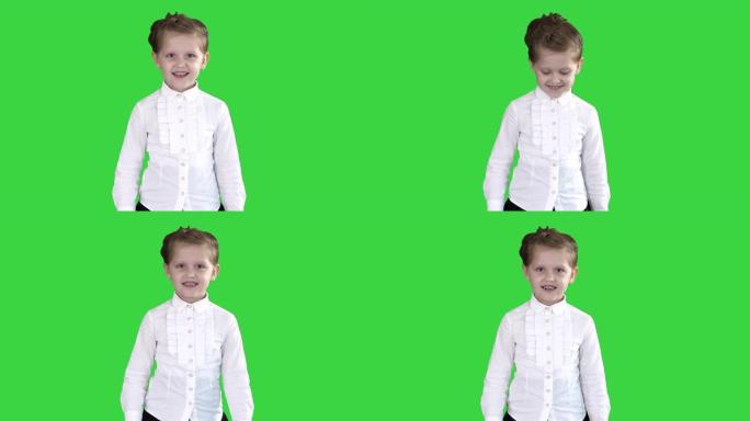 小女孩在绿色屏幕上行走和微笑，色键