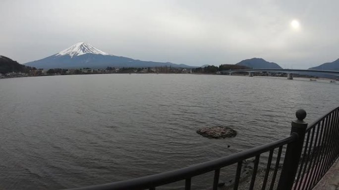 行走在河口湖的湖边，背景为富士山。