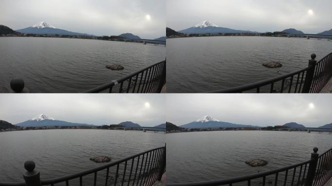 行走在河口湖的湖边，背景为富士山。