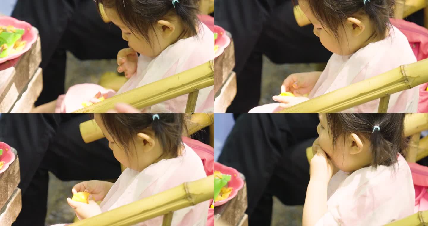小女孩在竹椅上吃水果