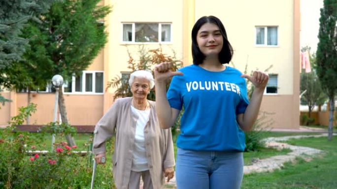 微笑的年轻志愿者，背景上有快乐的老太太