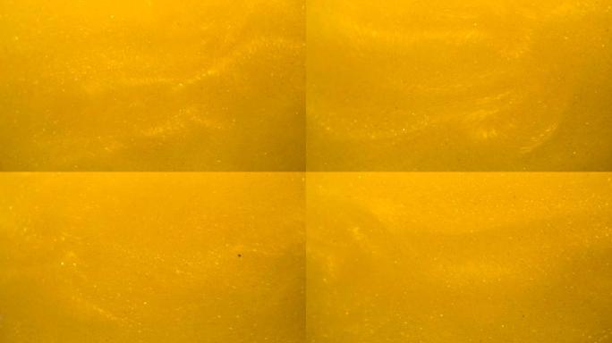 金波背景。艺术黄金背景。金色的沙子，灰尘创造了抽象的云层。慢动作。金色质地。惊人的变态闪耀闪亮粒子与