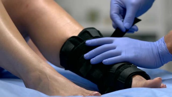 创伤专家在受伤的患者腿上戴脚踝包裹，进行创伤治疗
