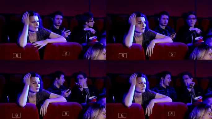 年轻人在电影院看无聊的电影。