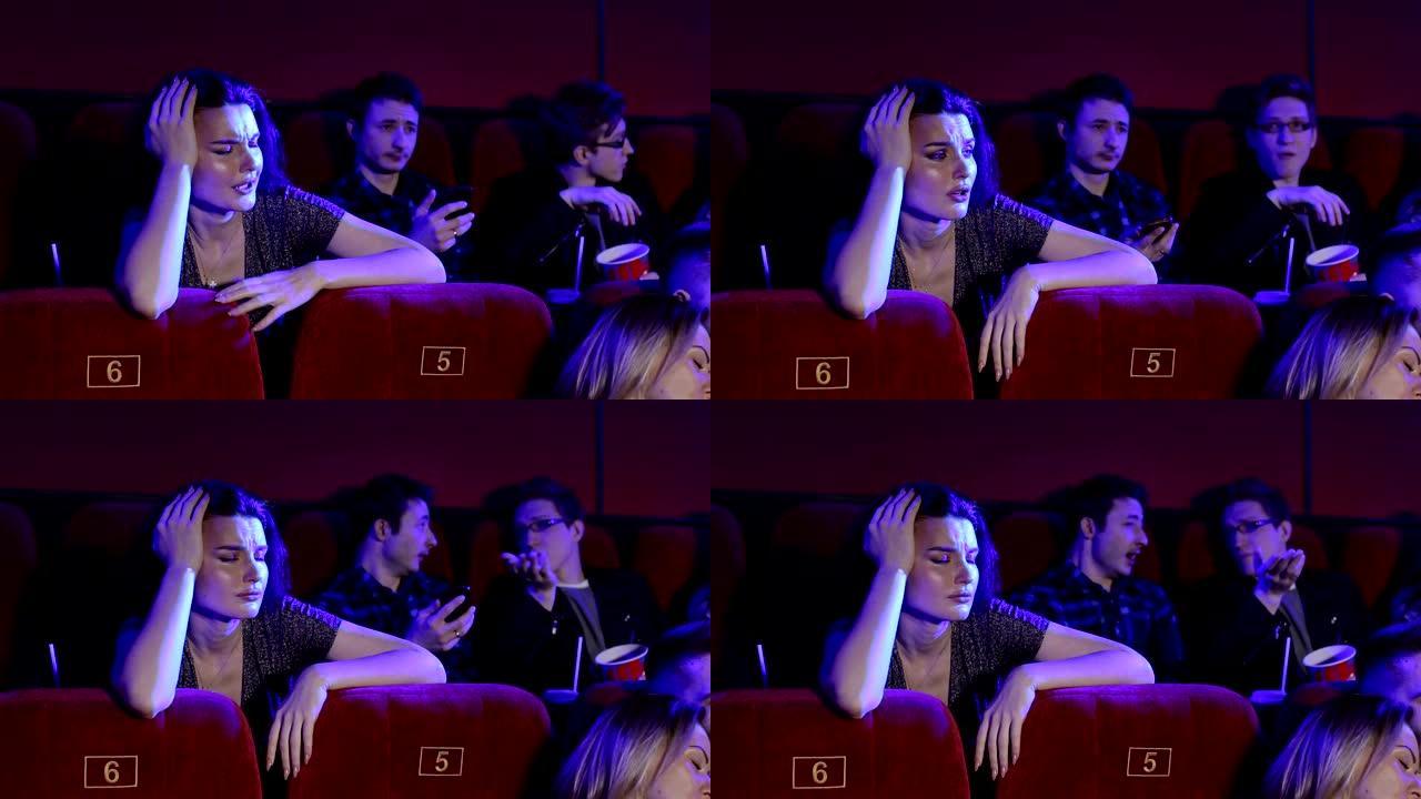 年轻人在电影院看无聊的电影。