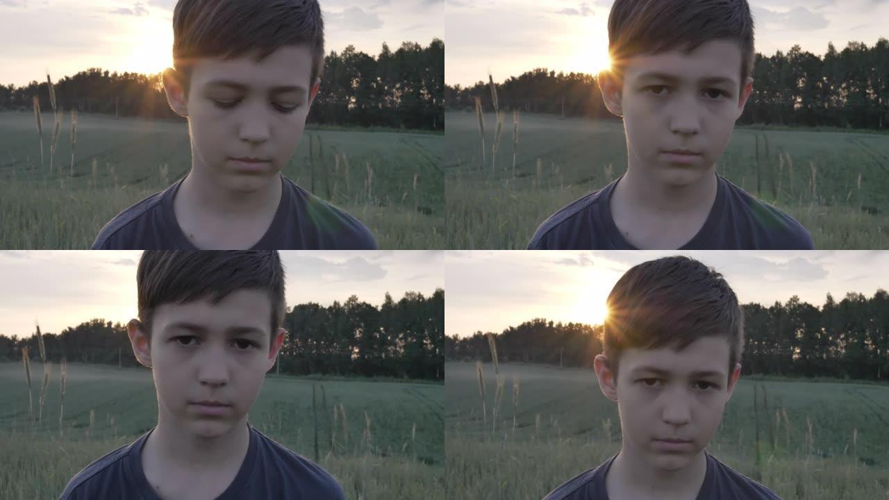 日落时麦田里悲伤男孩的肖像看着镜头特写