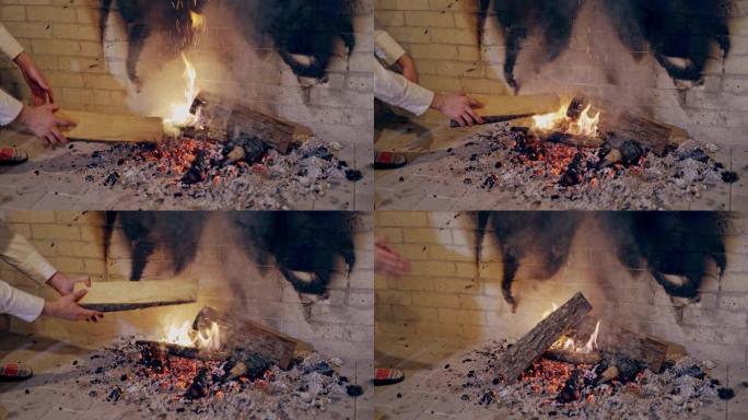 男性的手在室内用火炉劈开热量。