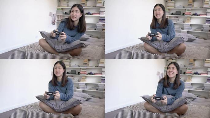 亚洲少女在家里的卧室里玩电子游戏快乐和激动人心的情感。使用操纵杆控制游戏。教育、科技、娱乐和放松的概