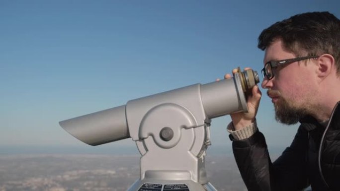 man将双筒望远镜聚焦在观景台上