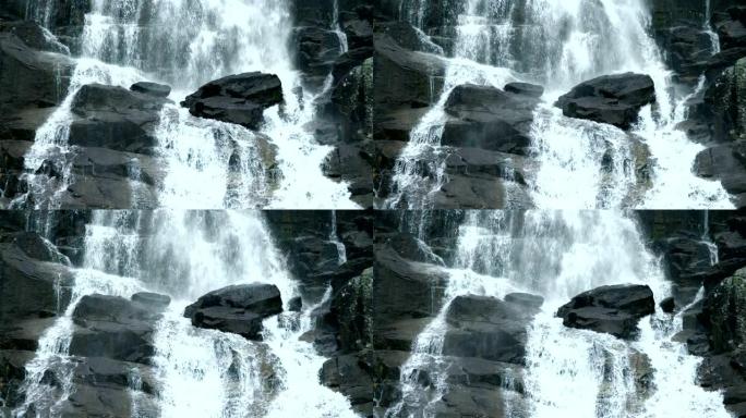 斯洛伐克Skok瀑布的石头上落水的慢动作镜头。喷出洪流。