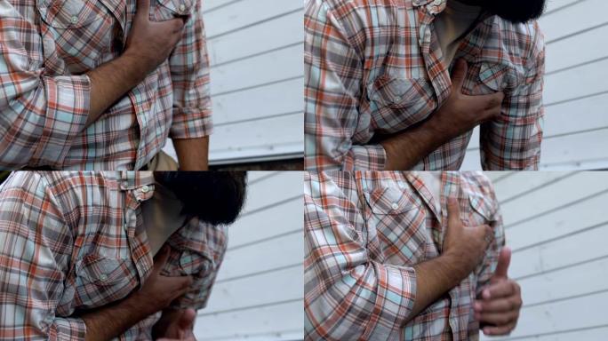 不健康的成年男子在街上接触心脏病发作的胸部，心脏健康