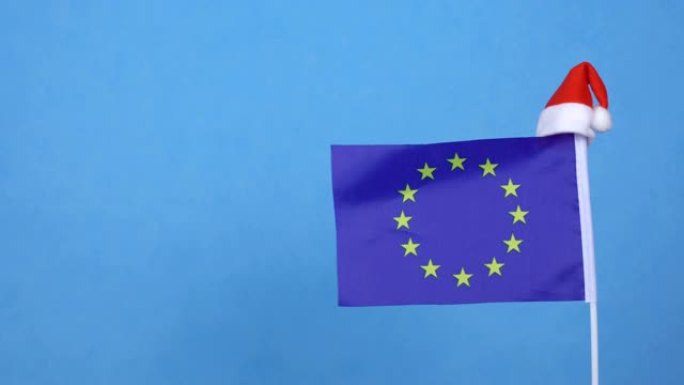 蓝色背景的欧盟旗帜和小圣诞老人帽。新年寒假概念，拷贝空间