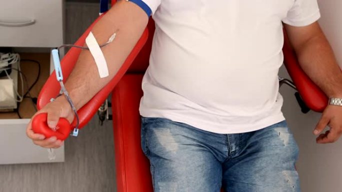 善行。为身体献血的好处。接受输血的接受者的手。在医疗诊所献血的献血者的特写