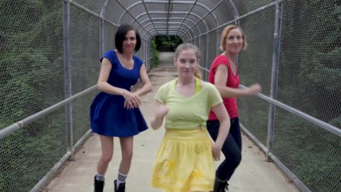 三个女人转身开始自由式在桥上朝相机跳舞
