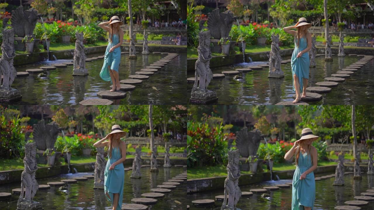 一名年轻女性游客参观印度尼西亚巴厘岛前皇宫Tirta Gangga水宫的慢镜头