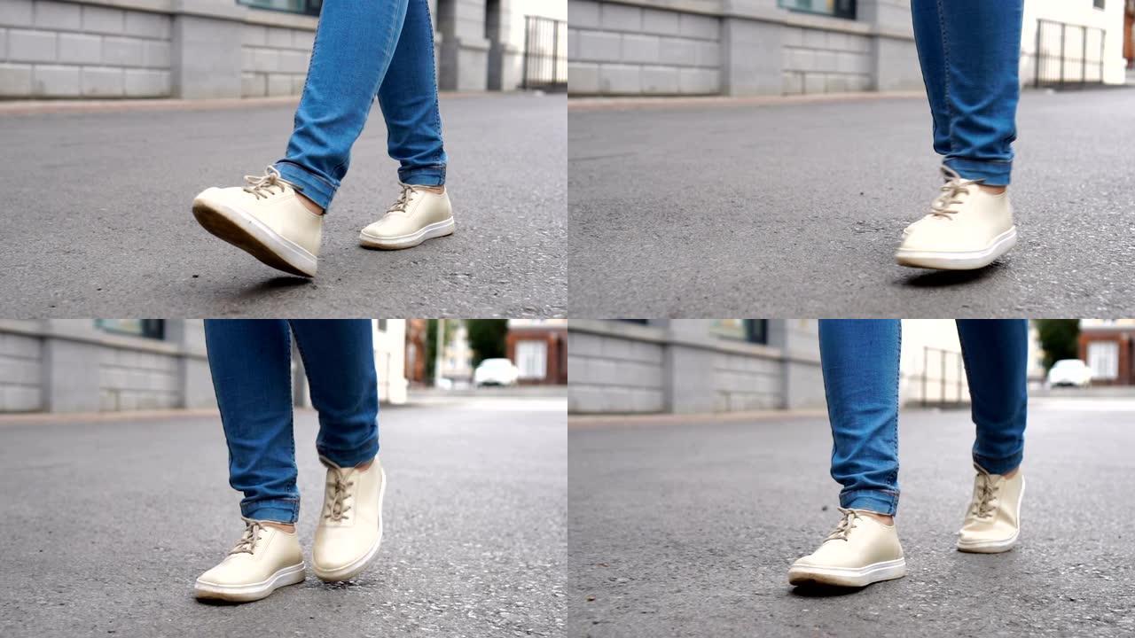 穿着运动鞋在瓷砖路上行走的女人的照片。城市环境。