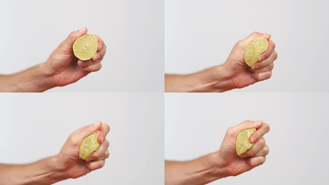 男性手握一块柠檬并将其挤出的特写镜头。柑橘汁从果肉和水滴中排出。孤立，在白色背景上
