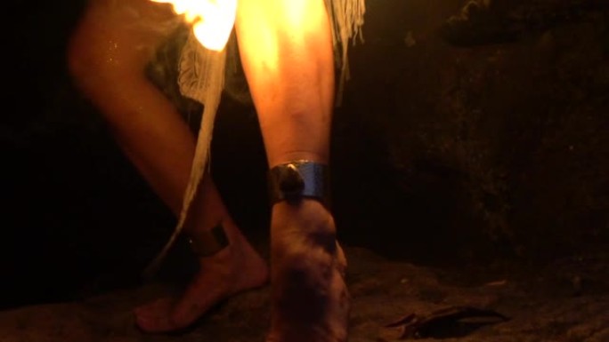 一个山洞里的女孩危险地通过她的身体生火。