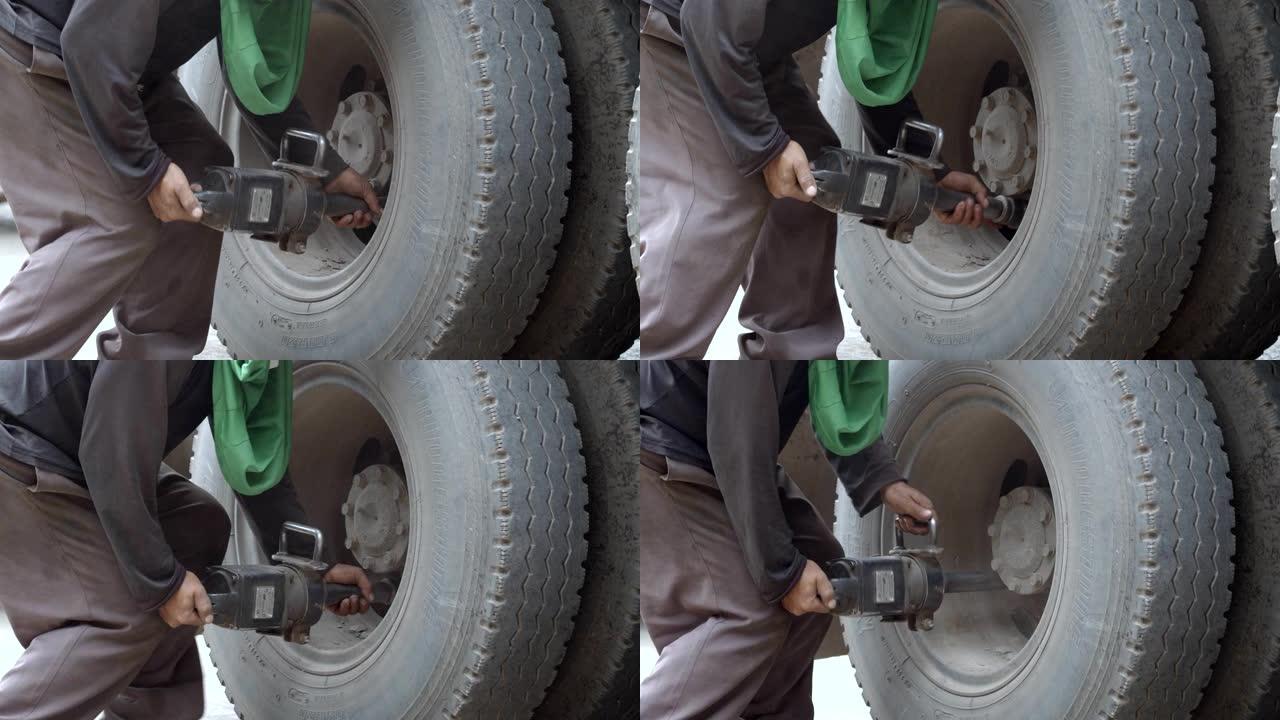 亚洲工人在用重型气枪拧紧车轮螺母时，用热钢号冲压轮胎，用手工组装轮胎。4k慢动作。
