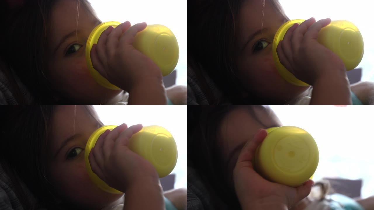 小女孩用塑料瓶喝水