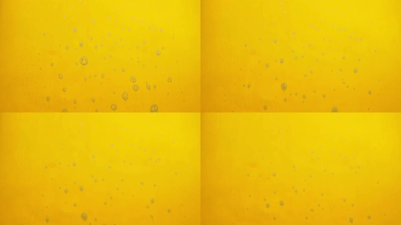 黄色背景上流动的肥皂产生泡沫。