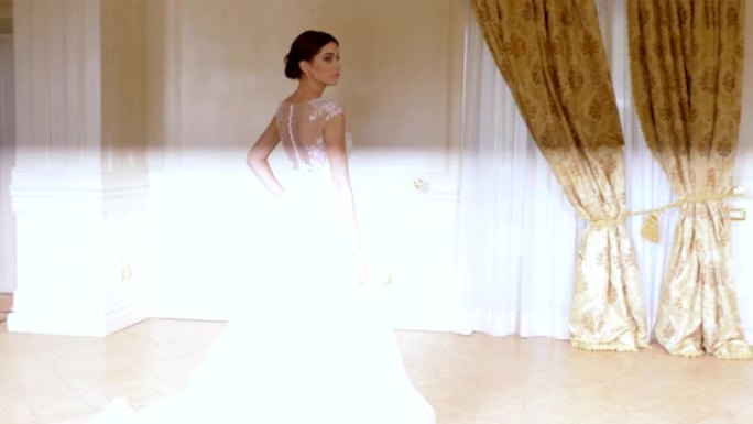 迷人的模特穿着美丽优雅的新娘礼服为摄影师摆姿势