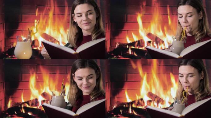 舒适，微笑的女孩坐在壁炉旁，在书中阅读有趣的故事，并在与朋友的聚会中喝在家中制作的传统蛋酒鸡尾酒