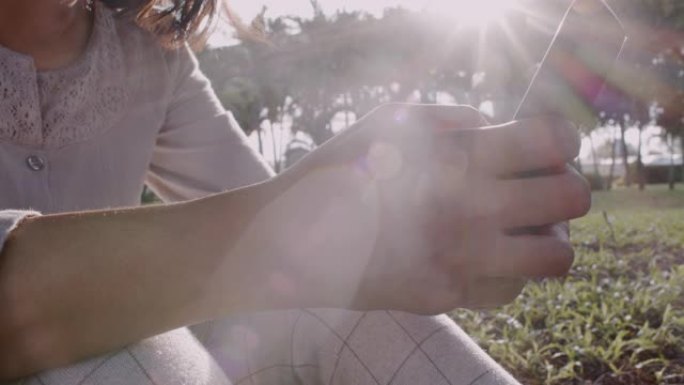 公园里日出时，女人的手触摸屏智能手机