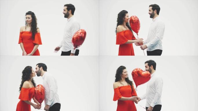 情人节夫妇。美少女和她英俊的男朋友拿着心形气球接吻。幸福快乐的家庭。爱。情人节。
