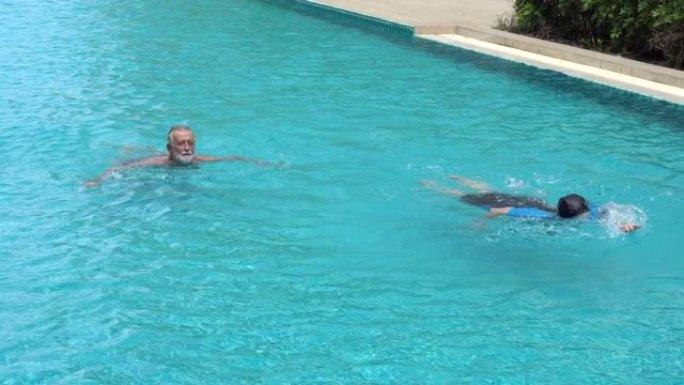 老年夫妇混合种族一起游泳。老人和女人在游泳池里锻炼。成熟的人锻炼。老年运动。健康的生活方式。退休培训