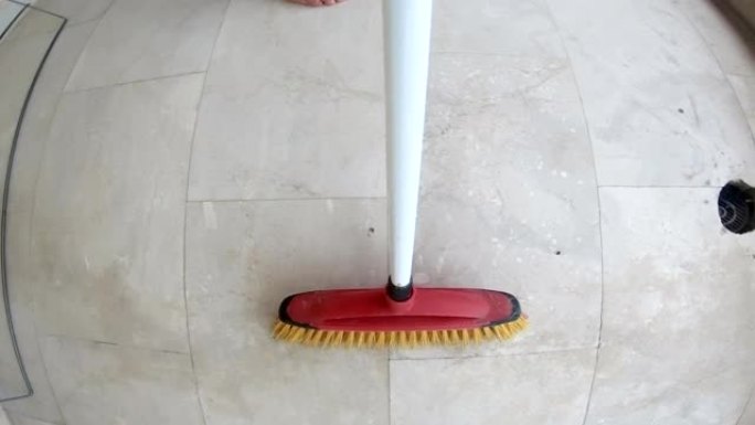 用扫帚扫除瓷砖地板上的灰尘，pov