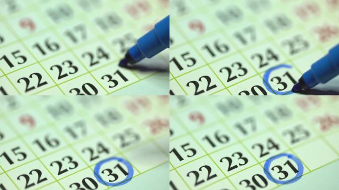 每月31日-31日。女人用蓝色记号笔标记日历日期。商务挂历规划器和组织者