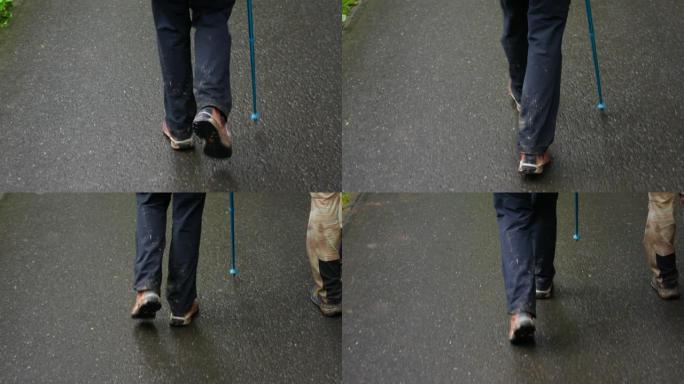 一名男子拄着追踪棒走在柏油路上，只看得见他的双腿