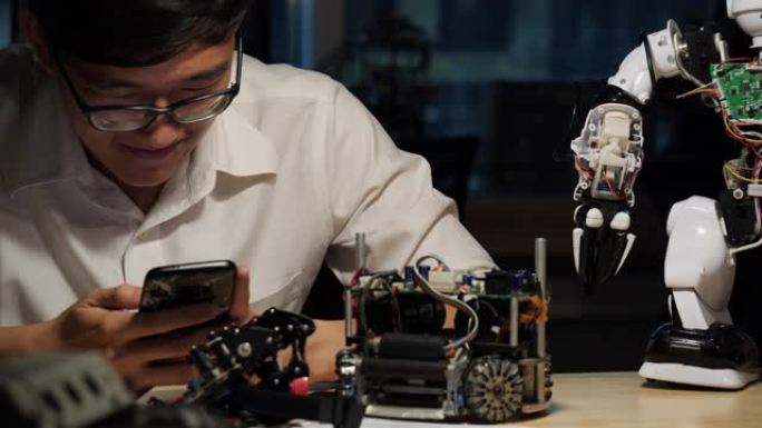 亚洲工程师男性在实验室组装和测试机器人反应。小工具、发展和生产力的概念。