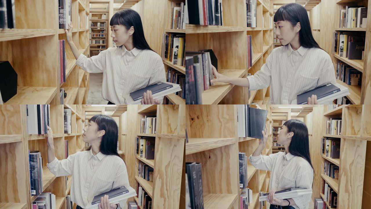 年轻可爱的亚洲女大学生在图书馆找一本书 (慢动作)